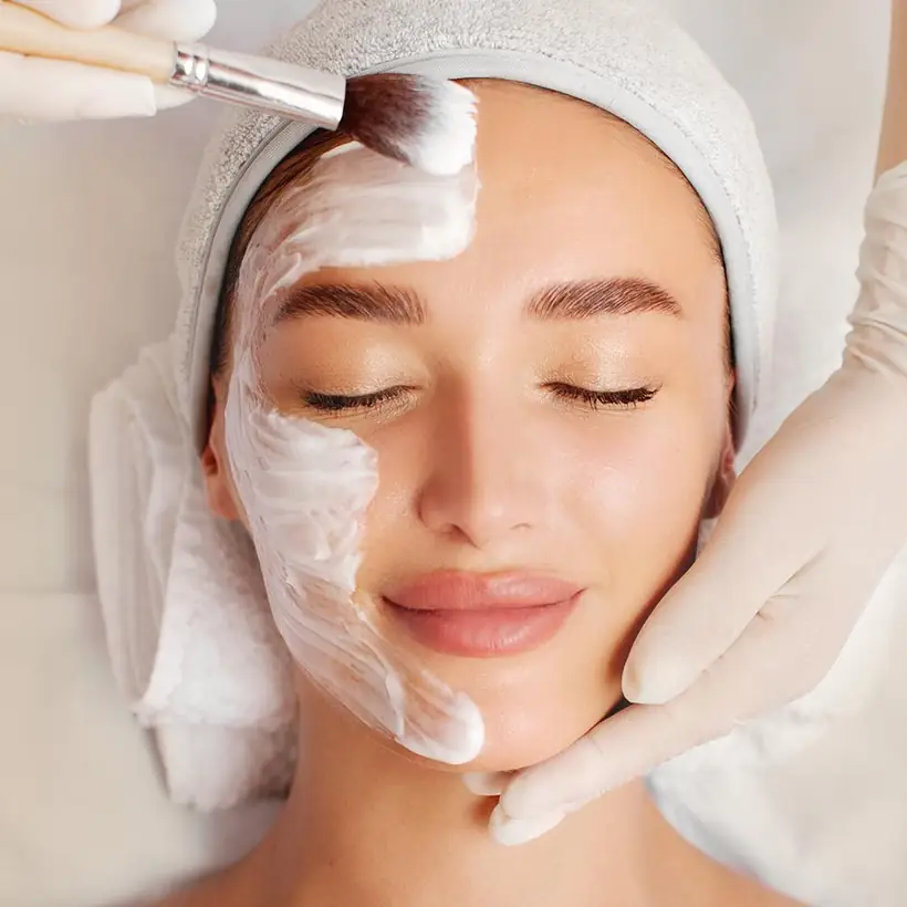 Aplicação do peeling coreano no rosto com pincel, em sessão de cuidado de pele